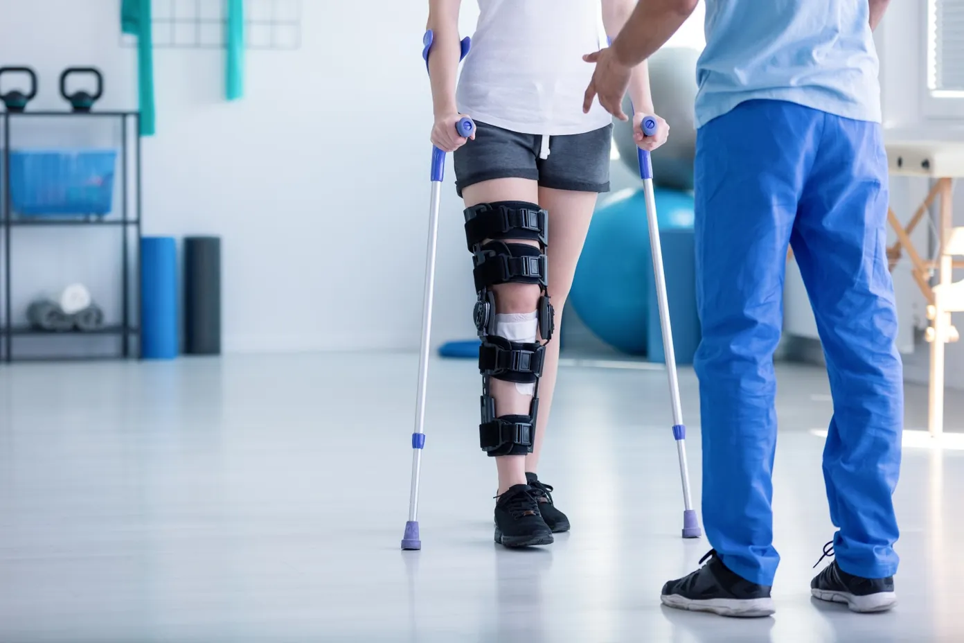 Patient in leg brace doing rehabilitation exercises