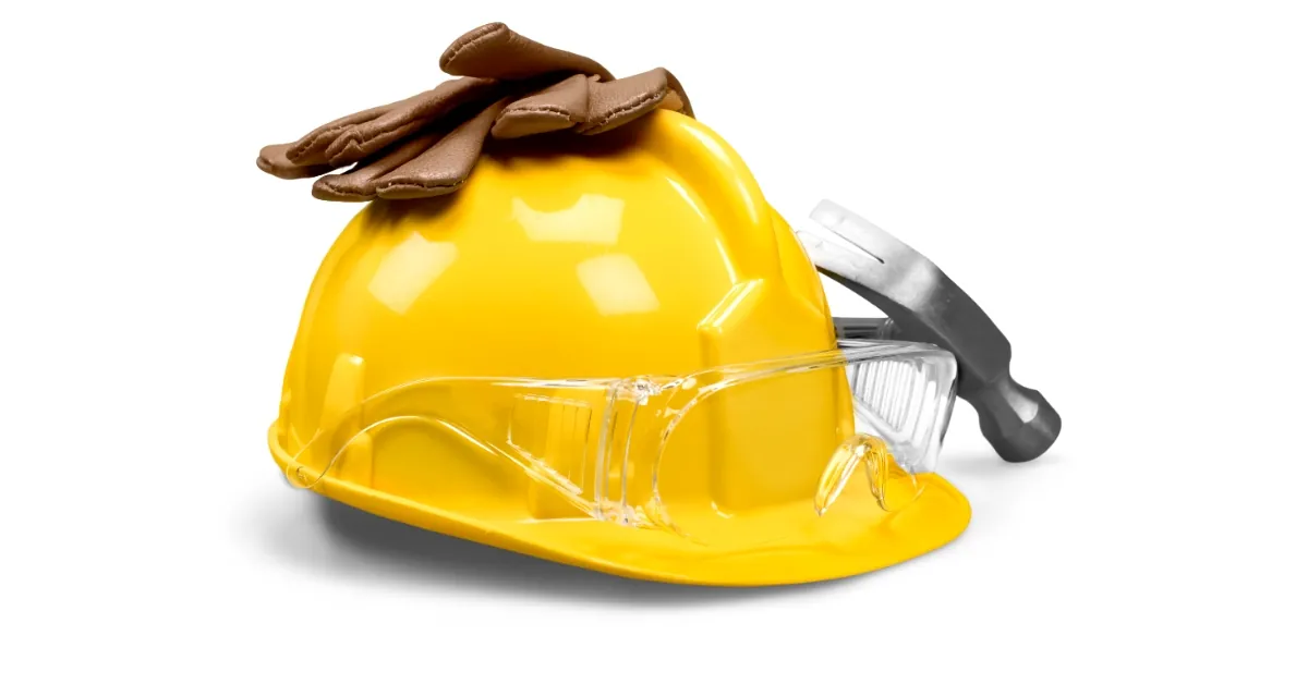 Hard hat, safety goggles, gloves and a hammer — workplace safety equipment